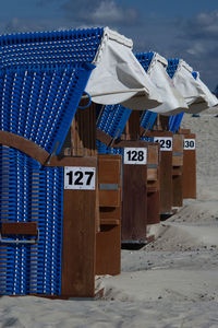 Row of hooded chairs on beach