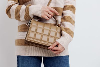 Midsection of woman holding gift against white background