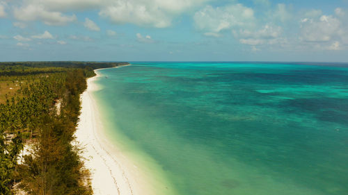 Tropical island with sandy beach by atoll with coral reef and blue sea, aerial view. bugsuk island 