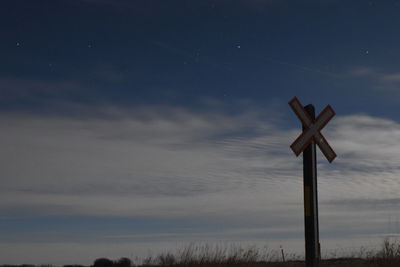 Low angle view of cross sign against sky