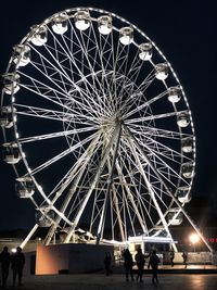 Low angle view of illuminated ferris wheel against sky at night