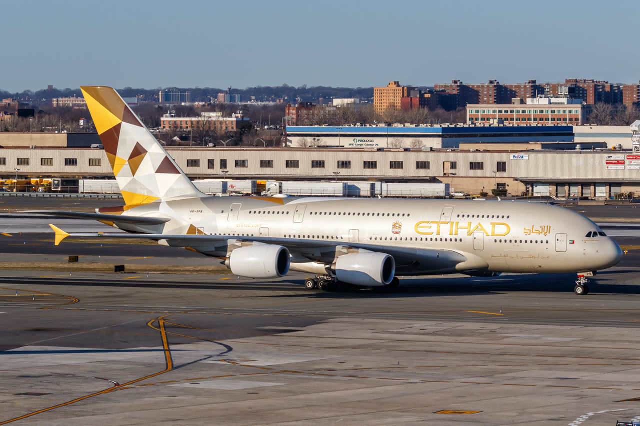 AIRPLANE AT AIRPORT RUNWAY AGAINST SKY