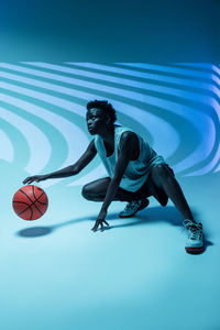 Low angle view of people playing ball against blue sky