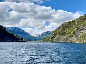 Scenic view of lake by mountains against sky