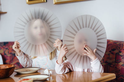 Reflection of people on table in plate