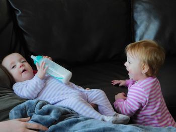 Cute siblings on bed at home