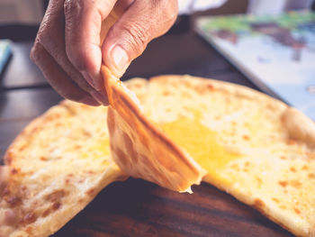 Close-up of hand holding pizza