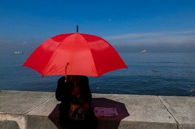 Rear view of woman sitting on beach