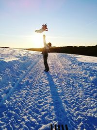 Woman with arms raised against clear sky