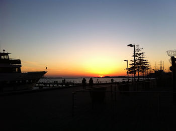 Silhouette pier over calm sea at sunset