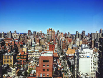 High angle view of buildings against blue sky