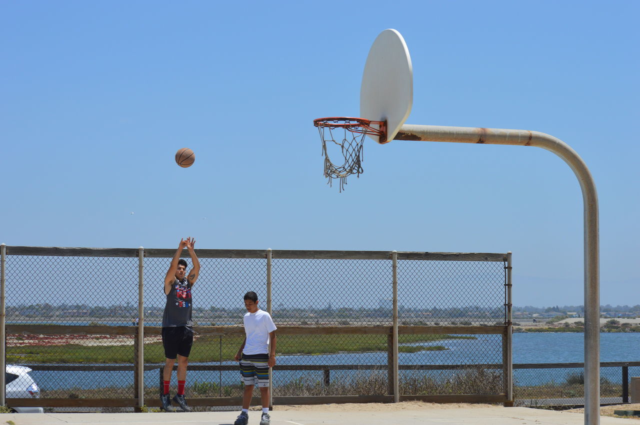 PEOPLE PLAYING BASKETBALL HOOP