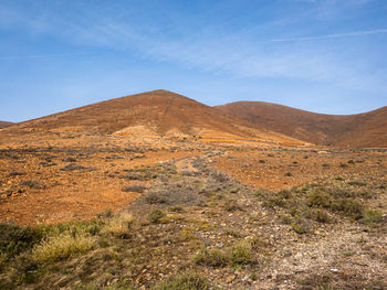 Scenic view of mountains against blue sky