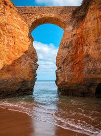 Rock formations by sea against sky