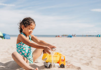 Side view of woman sitting at beach