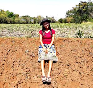 Portrait of young woman standing on field