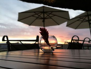 Close-up of table against sea during sunset