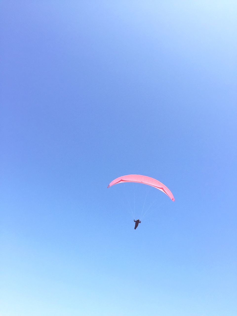 flying, mid-air, low angle view, clear sky, parachute, freedom, extreme sports, copy space, blue, paragliding, kite - toy, exhilaration, adventure, motion, parachuting, kite, fun, sky, multi colored, leisure activity