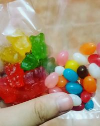 Close-up of hand holding multi colored candies