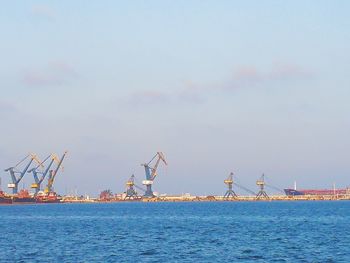 Commercial dock by sea against sky