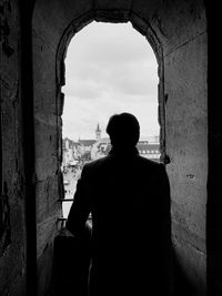 Rear view of silhouette man standing against sky