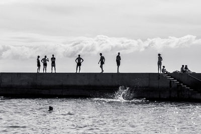 People enjoying in sea against sky