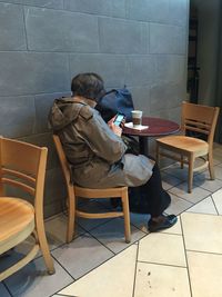 High angle view of man sitting on chair