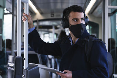 Portrait of young man standing in bus