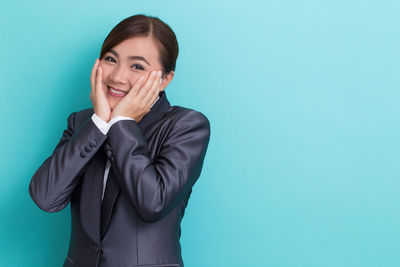 Portrait of a smiling young woman against blue background