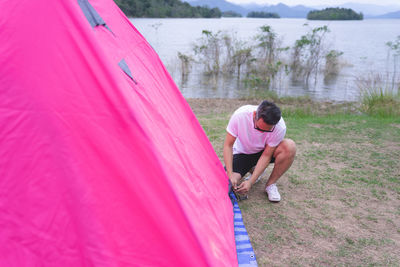 Man arranging tent on land