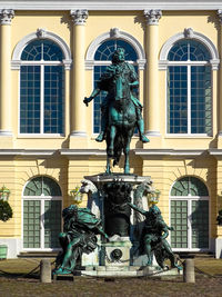 Statue of fountain in front of historical building