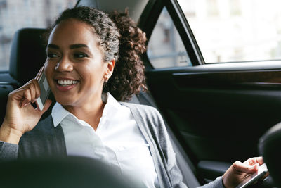 Businesswoman using phone while sitting in car