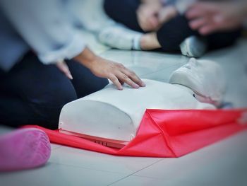 Midsection of person with cpr dummy during training