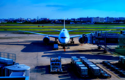 High angle view of airplane on airport runway against sky