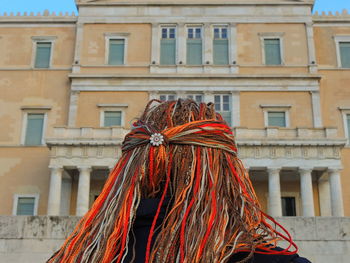 Low angle view of person with braided hair against building