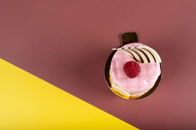 Close-up of apple on glass against pink wall