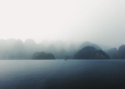 Scenic view of sea and mountains against sky