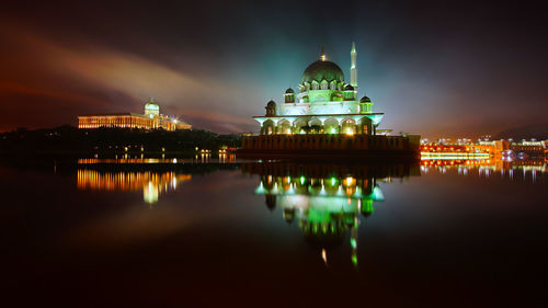 Reflection of illuminated temple in water at night