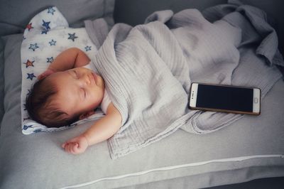 High angle view of baby sleeping on bed