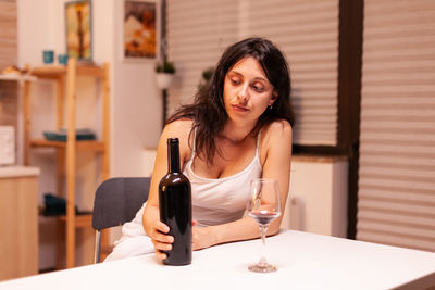 Portrait of young woman using mobile phone at home