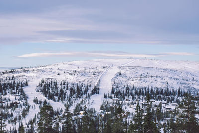 Snow covered landscape against sky