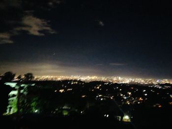 Illuminated city against sky at night