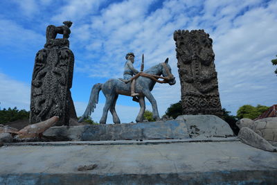 Low angle view of statue against cloudy sky