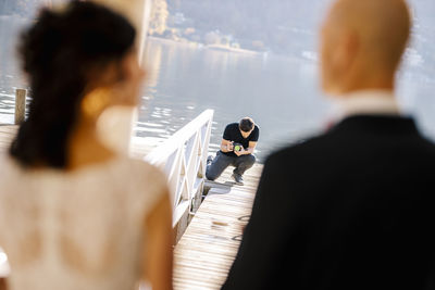 Photographer filming wedding couple by lake