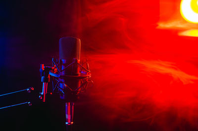 Low angle view of illuminated lighting equipment at night