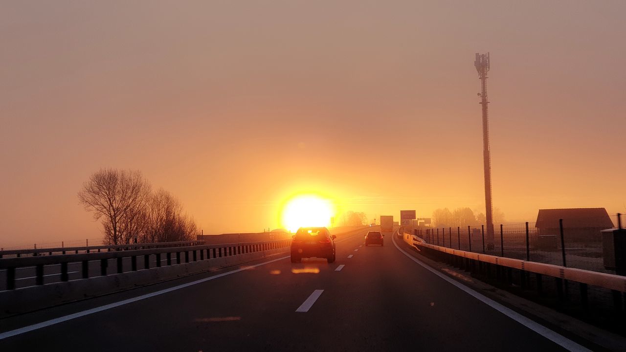 sunset, transportation, sky, road, land vehicle, mode of transportation, motor vehicle, car, direction, sun, the way forward, architecture, orange color, nature, street, city, built structure, no people, connection, sunlight, bridge - man made structure, outdoors, diminishing perspective