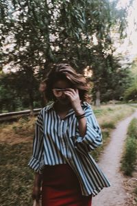 Young woman walking on road in forest