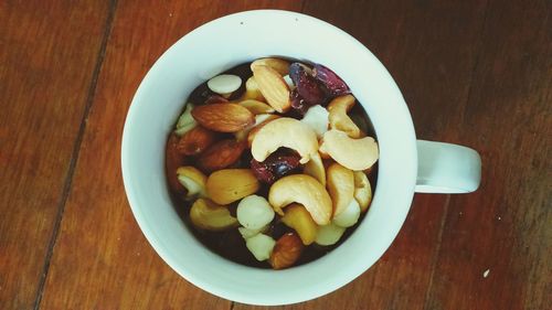 Close-up of dry fruits in coffee cup on table