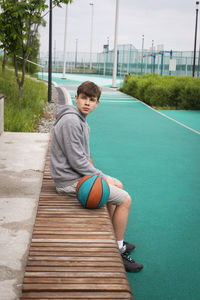 Portrait of young man sitting on bench