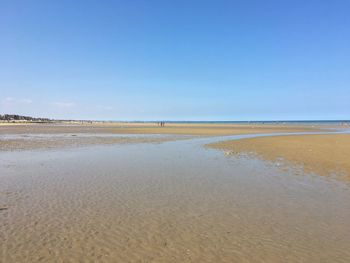 Scenic view of beach against clear blue sky